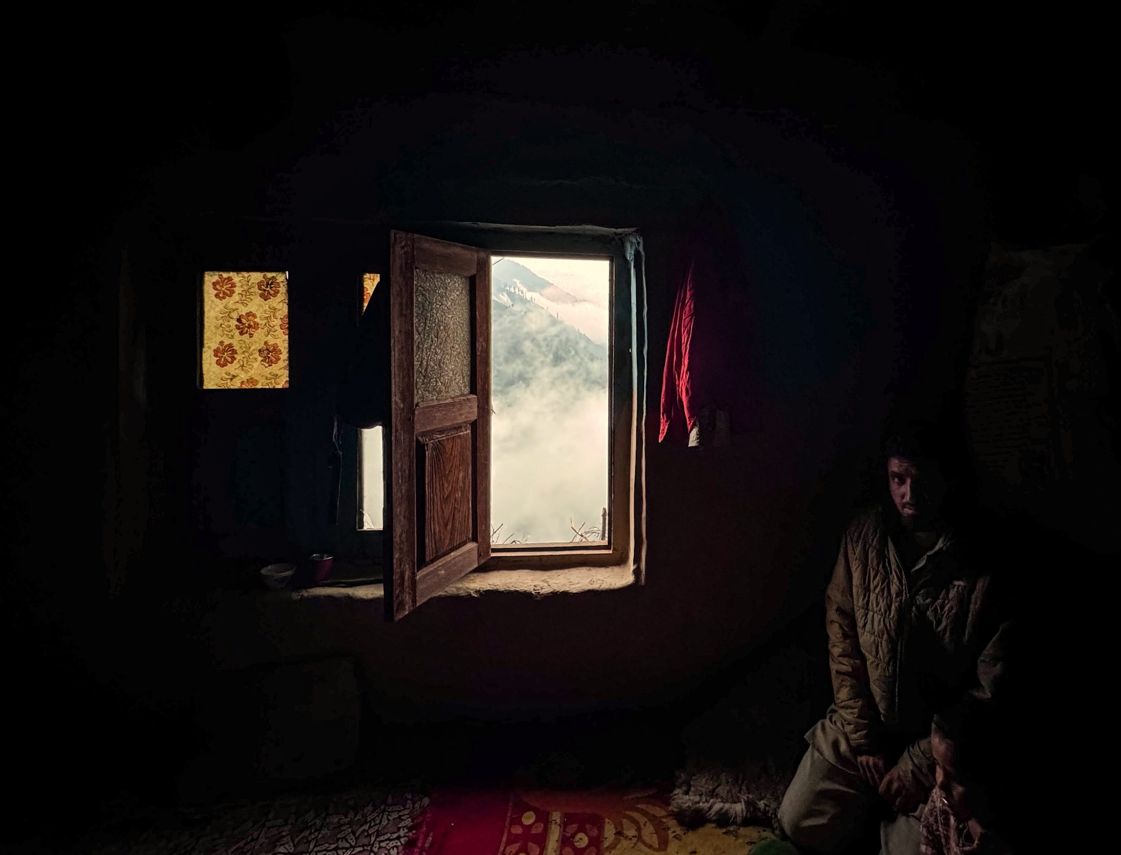 Dhadkai (INDIA), 07/26/2026. Light enters a home through an open window overlooking the mountains around Dhadkai, in Jammu and Kashmir's Doda district. The Parlor Magazine/Luqmaan Zeerak