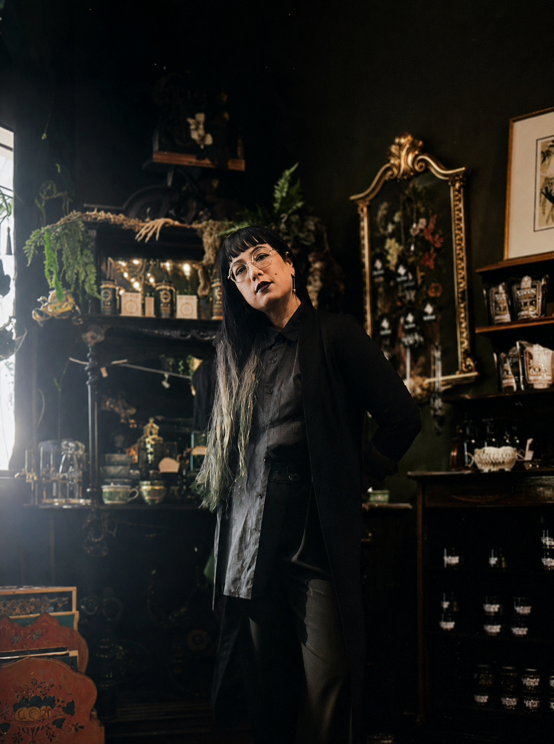 AJ Hawkins inside Kalma, surrounded by the shop's curated apothecary shelves and antique décor. (Photo courtesy of AJ Hawkins)